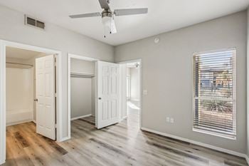 A room with a ceiling fan and a window with blinds